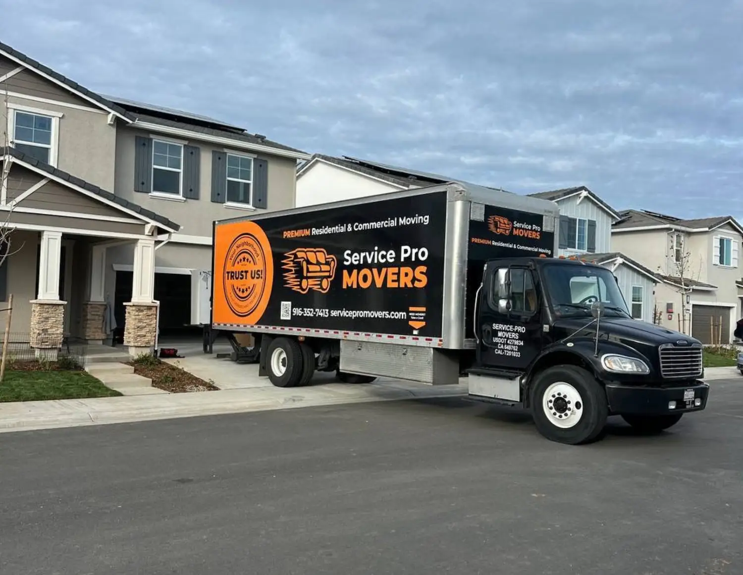 A truck from the moving company Service Pro Movers is being loaded before a long-distance move