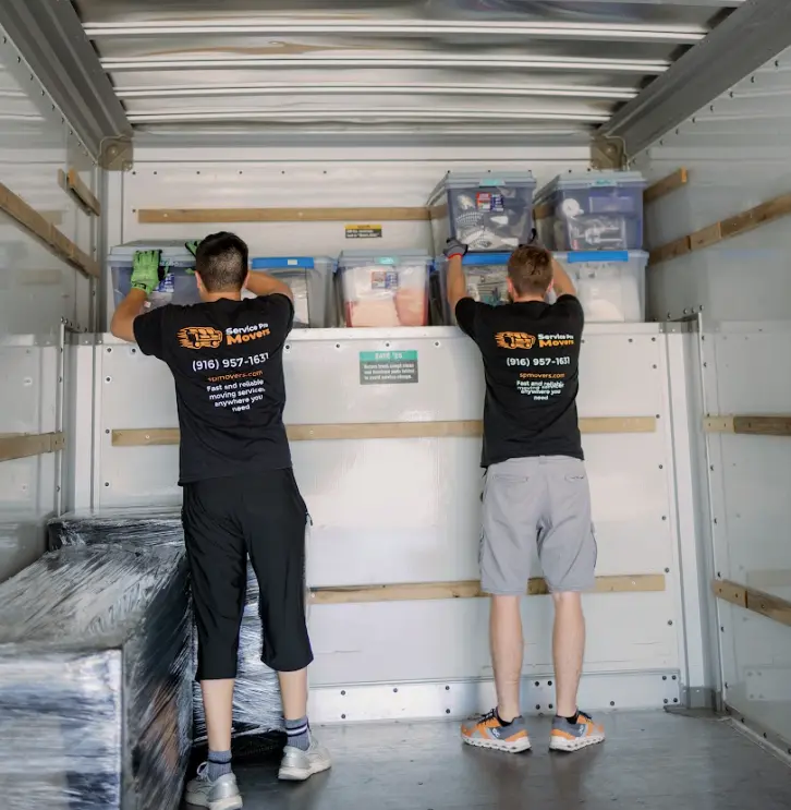 Movers loading office desks and chairs into Service Pro Movers truck in Sacramento